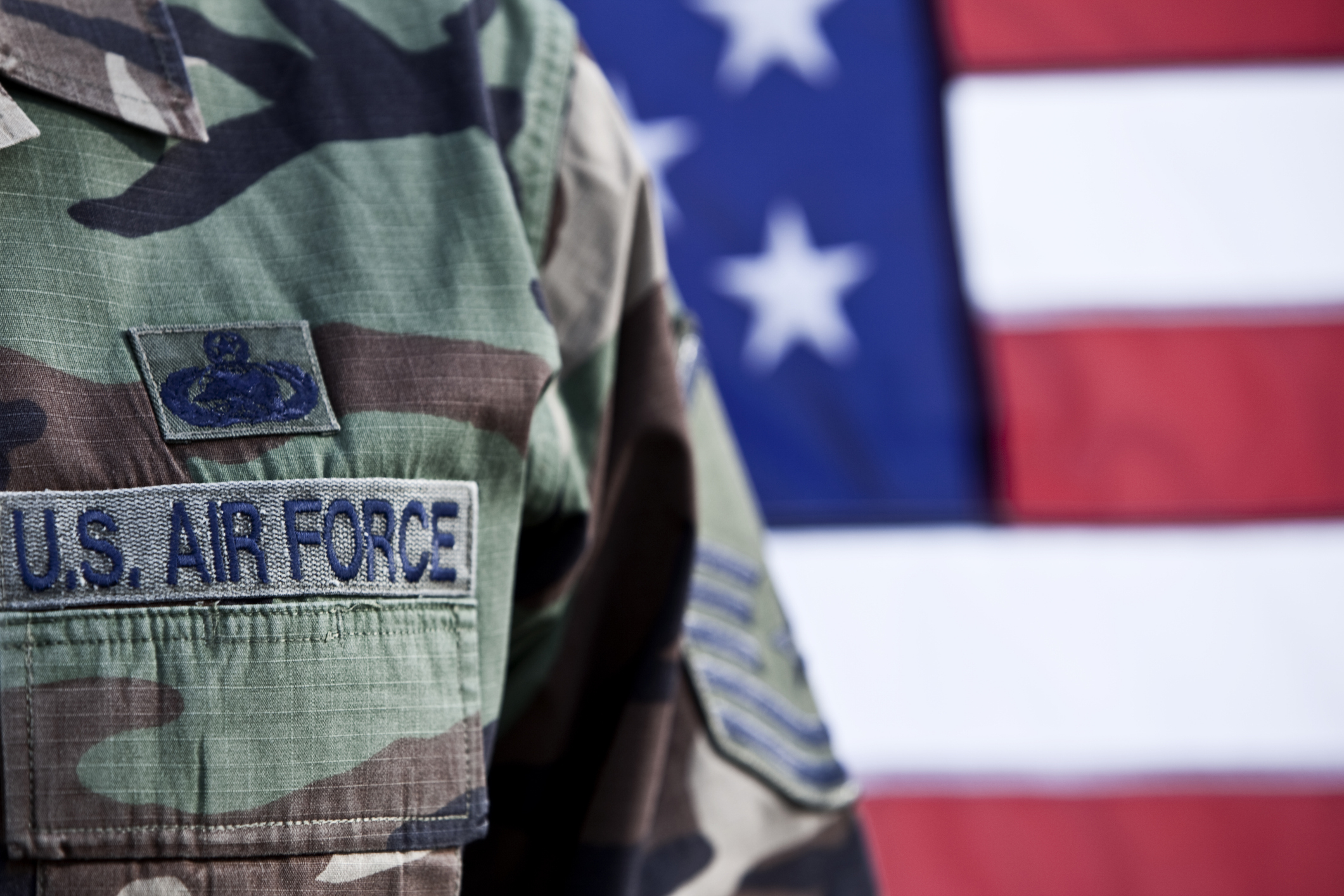 A U.S. Air Force camouflage uniform with an American flag in the background