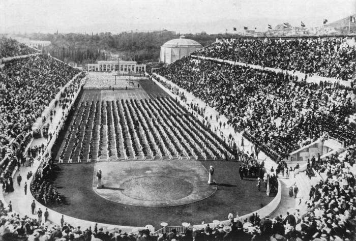 Historic photograph of the first modern Olympic Games in Athens, Greece, 1896, featuring a crowded stadium with athletes and spectators