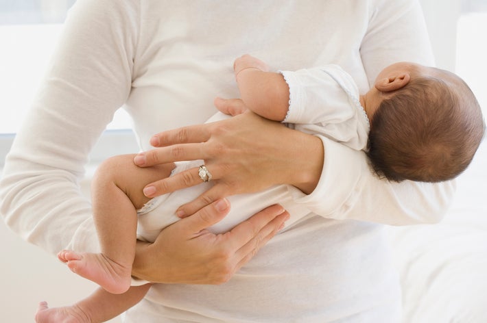 赤ちゃんを腕に抱えた人。