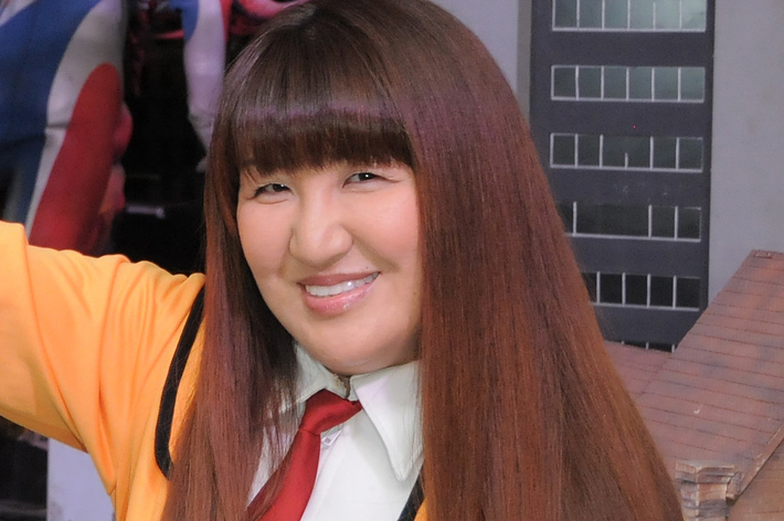 女性が笑顔でポーズをとっている。