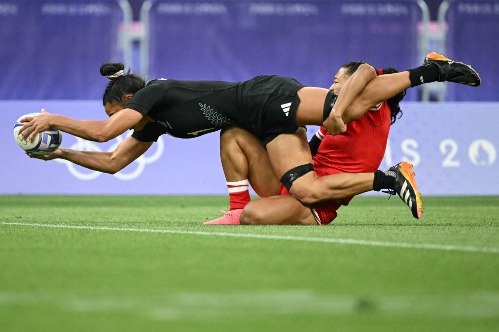 Ruby Tui scores a try for the New Zealand rugby team while being tackled by a Great Britain player during an Olympic match