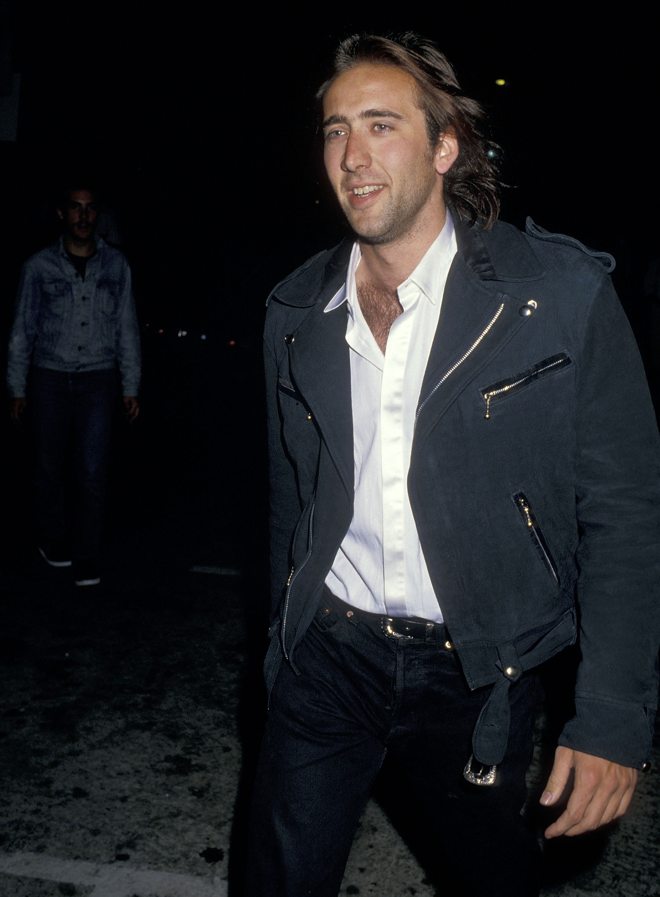 Nicolas Cage in a black jacket, white shirt, and black pants