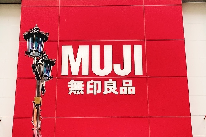 無印良品の店舗の外観。赤い看板に「MUJI 無印良品」と表示されています。