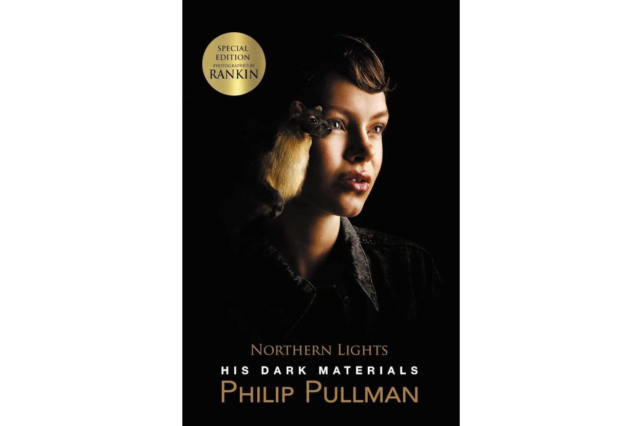 Book cover for &quot;Northern Lights&quot; by Philip Pullman, featuring a close-up of a person with a ferret on their shoulder. Text: &quot;Special Edition Rankin,&quot; &quot;His Dark Materials.&quot;