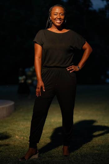 a reviewer lasting outdoors astatine night, wearing a stylish achromatic jumpsuit