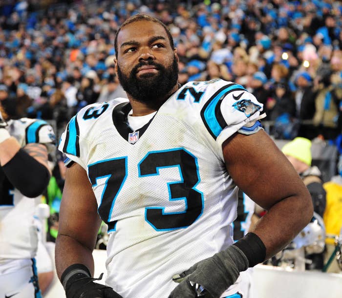 Michael Oher stands on the field wearing his Carolina Panthers football uniform, #73, with a focused expression