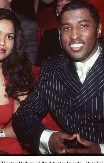 Babyface and wife sitting together at the 3rd annual Blockbuster Awards. Babyface is in a pinstripe suit, and his wife is wearing a sleeveless dress