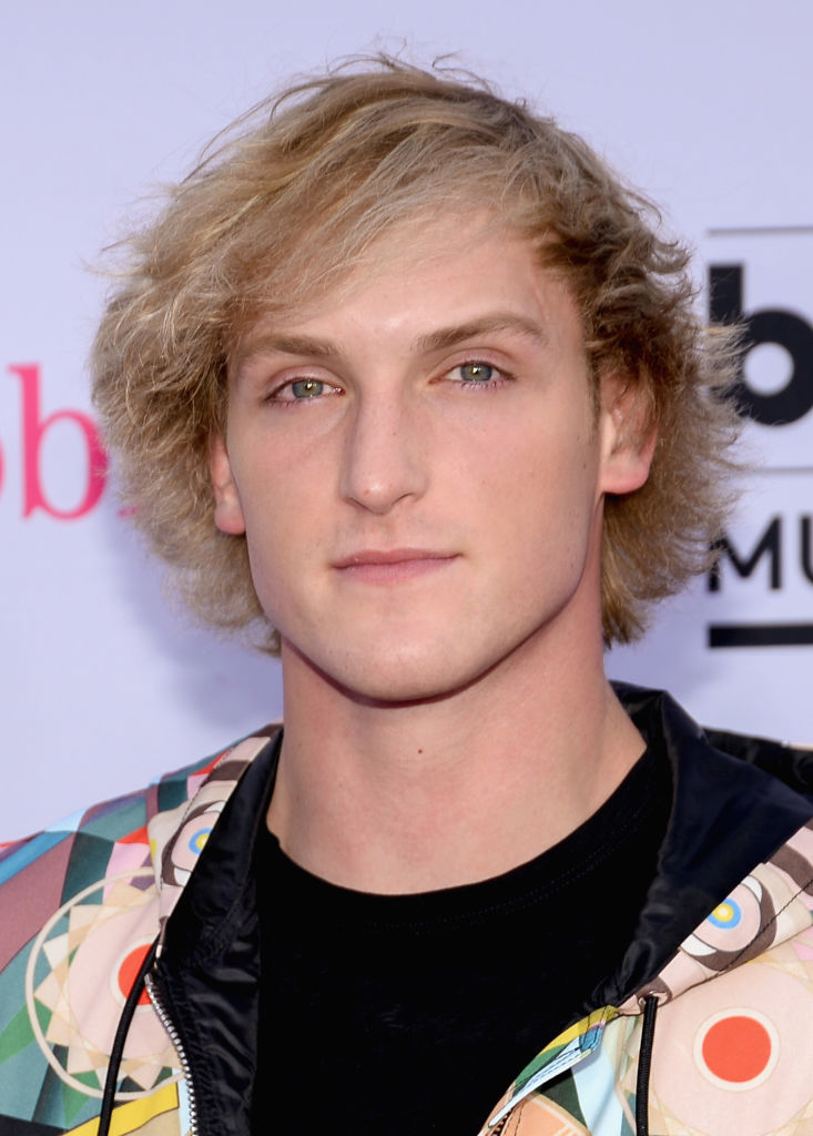 Logan Paul poses at an event wearing a patterned jacket over a black shirt