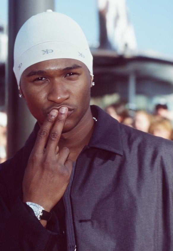 Usher wearing casual attire, including a white beanie, poses on the red carpet at the 1998 MTV Video Music Awards in Universal City, CA