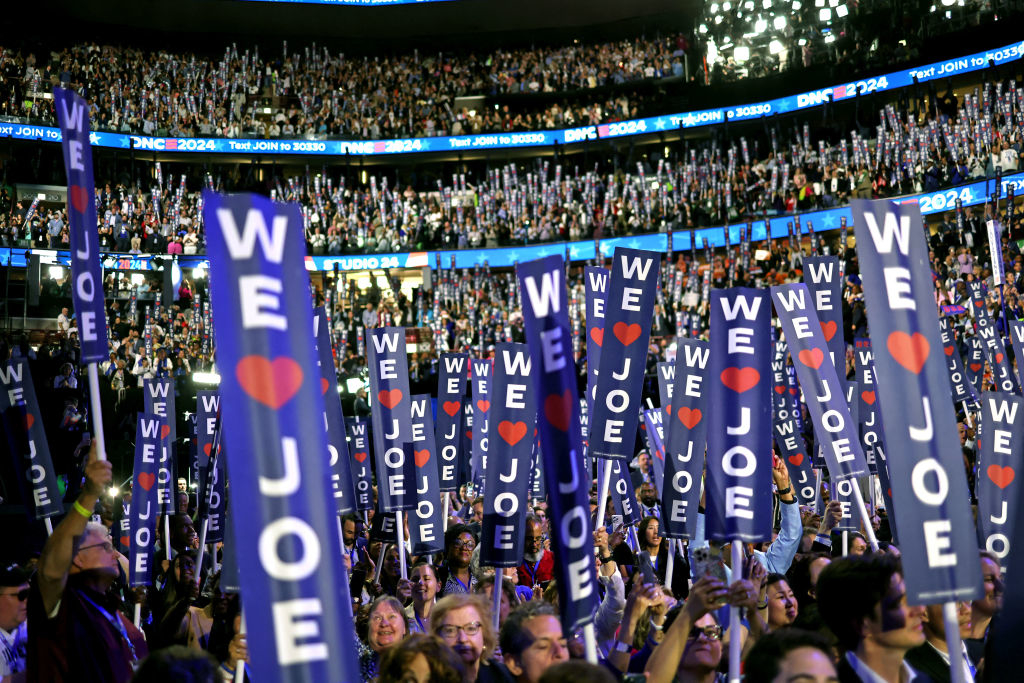 A large crowd holds &quot;We love Joe&quot; signs at a political rally, with numerous attendees and banners in view