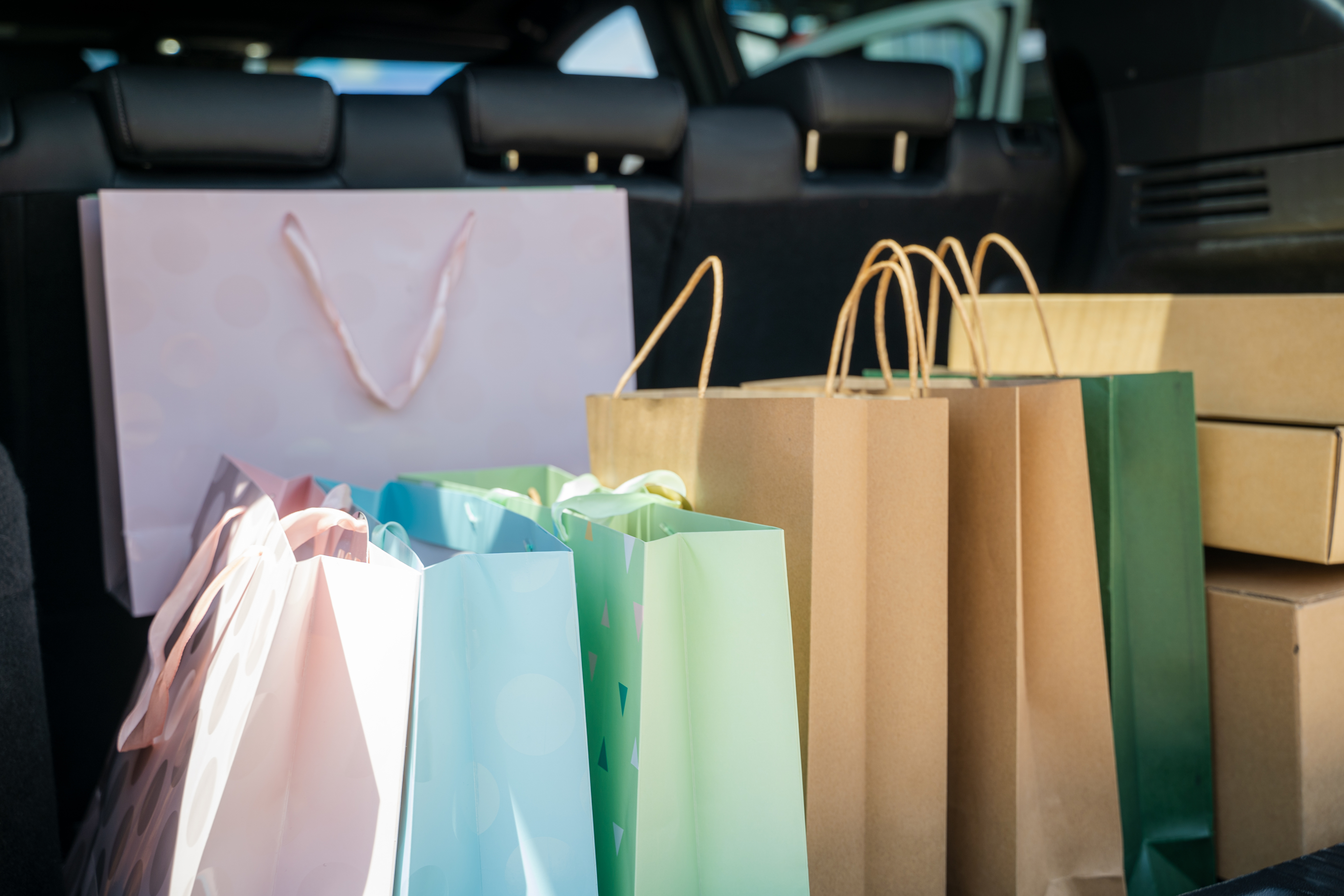 Shopping bags in the trunk of a car, containing various items