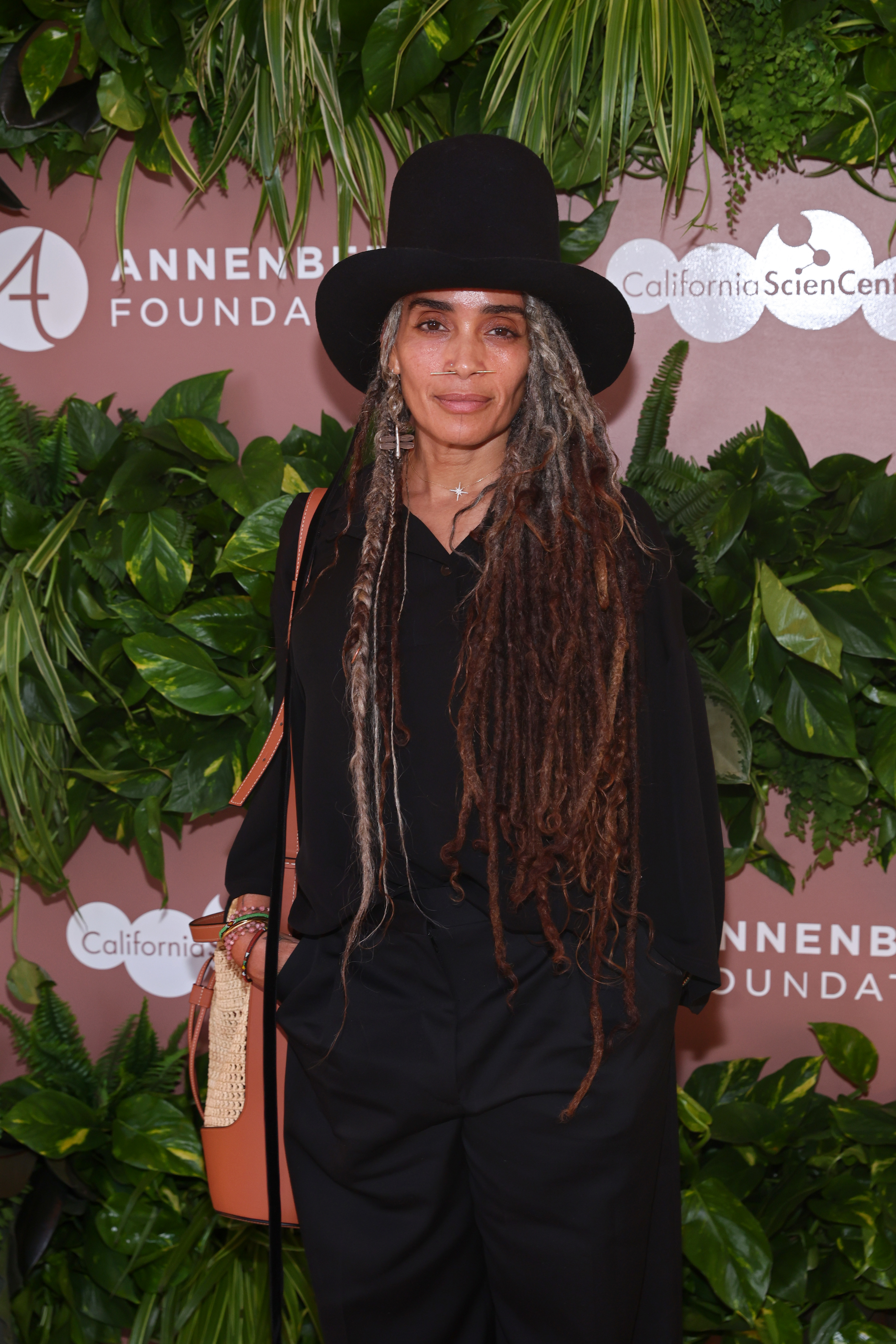 Lisa Bonet attends an event hosted by the Annenberg Foundation and California Science Center, wearing a black outfit, a wide-brimmed hat, and long dreadlocks