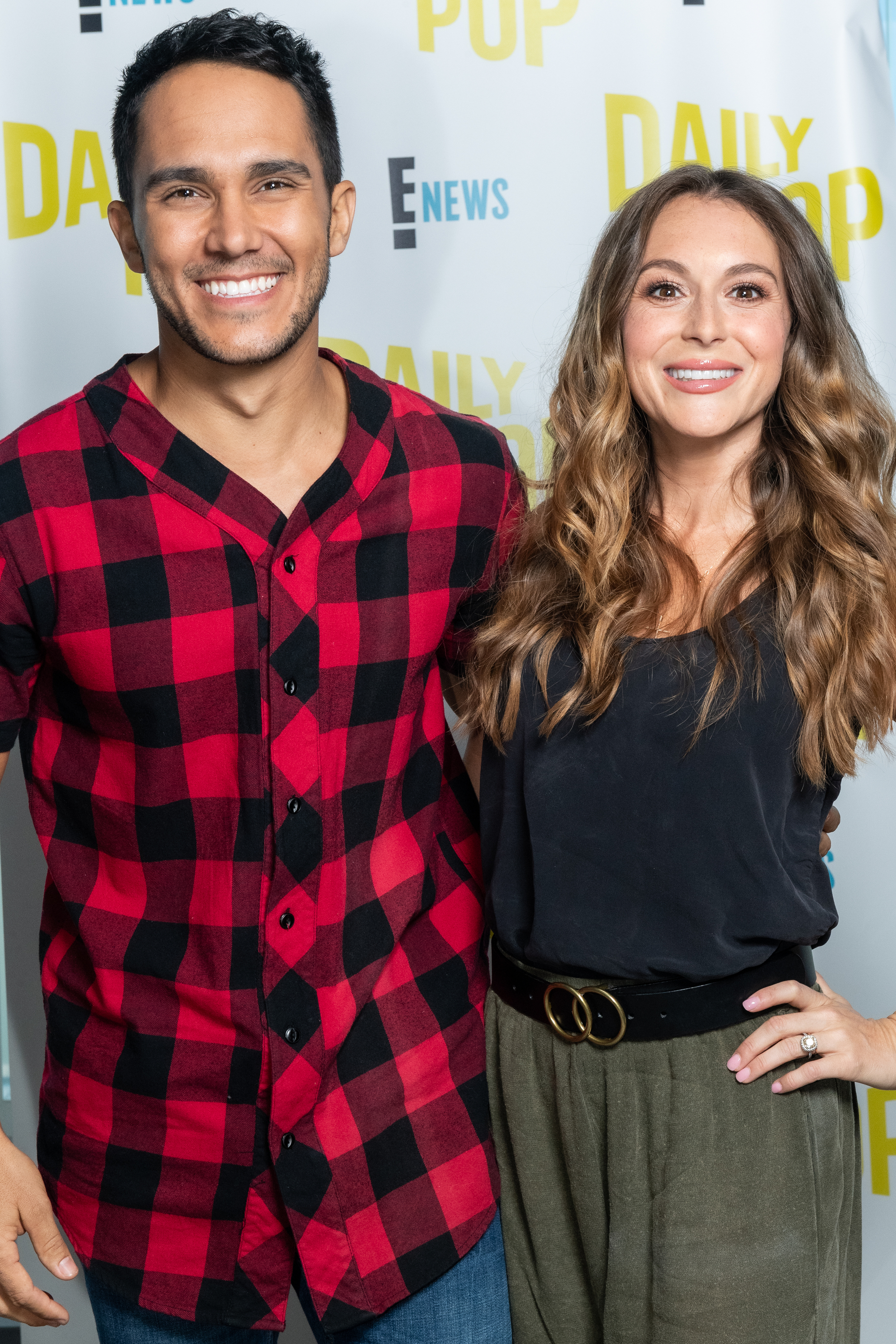 Carlos PenaVega in a red plaid shirt and Alexa PenaVega in a black blouse and high-waisted pants at the Daily Pop event