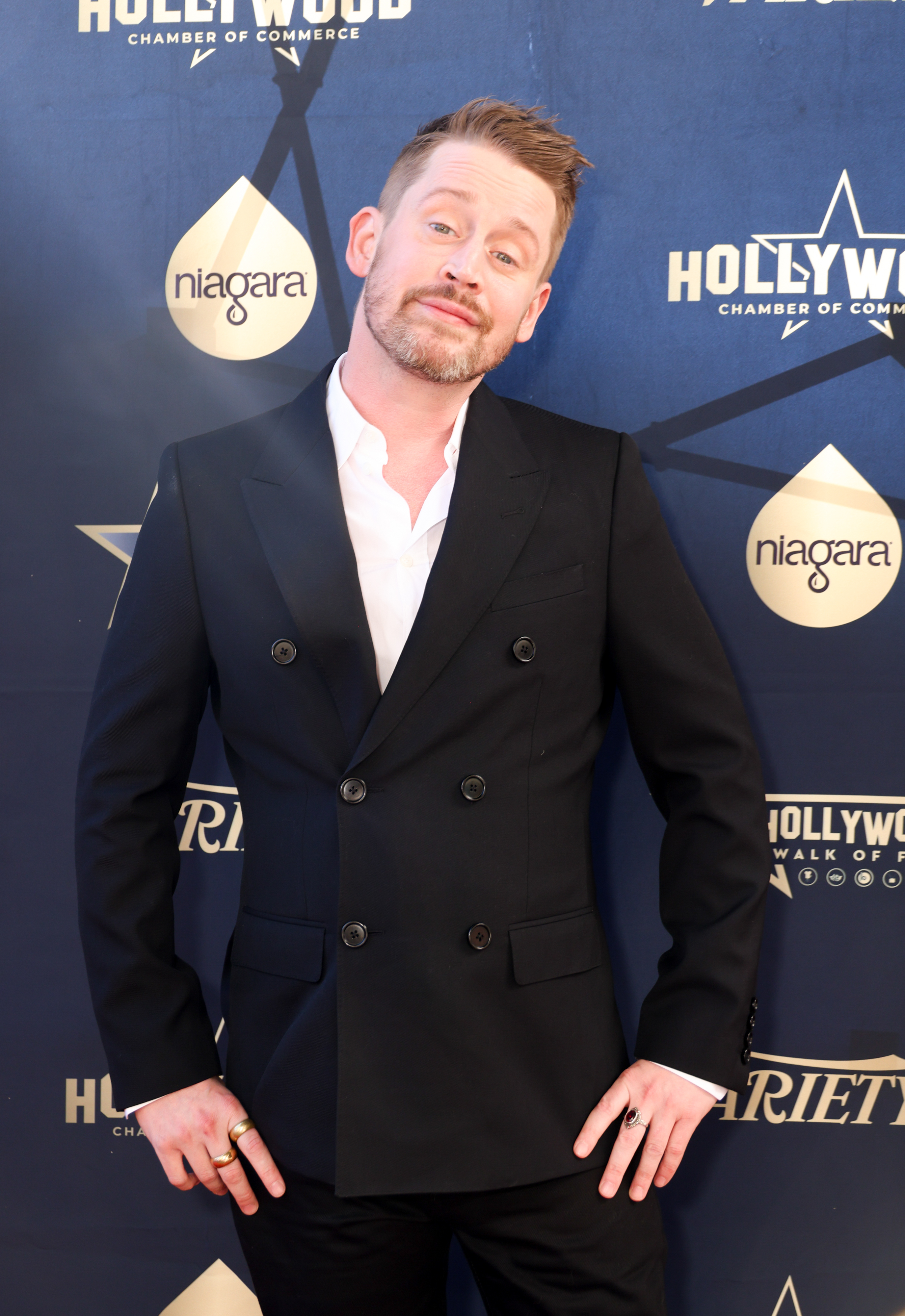 Macaulay Culkin poses in a black double-breasted suit jacket at a Hollywood Chamber of Commerce event