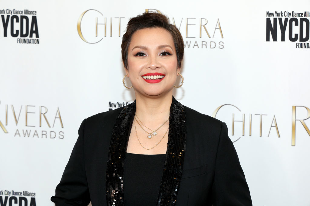 Lea Salonga smiles at the Chita Rivera Awards, wearing a dark outfit with a sequined blazer and gold hoop earrings
