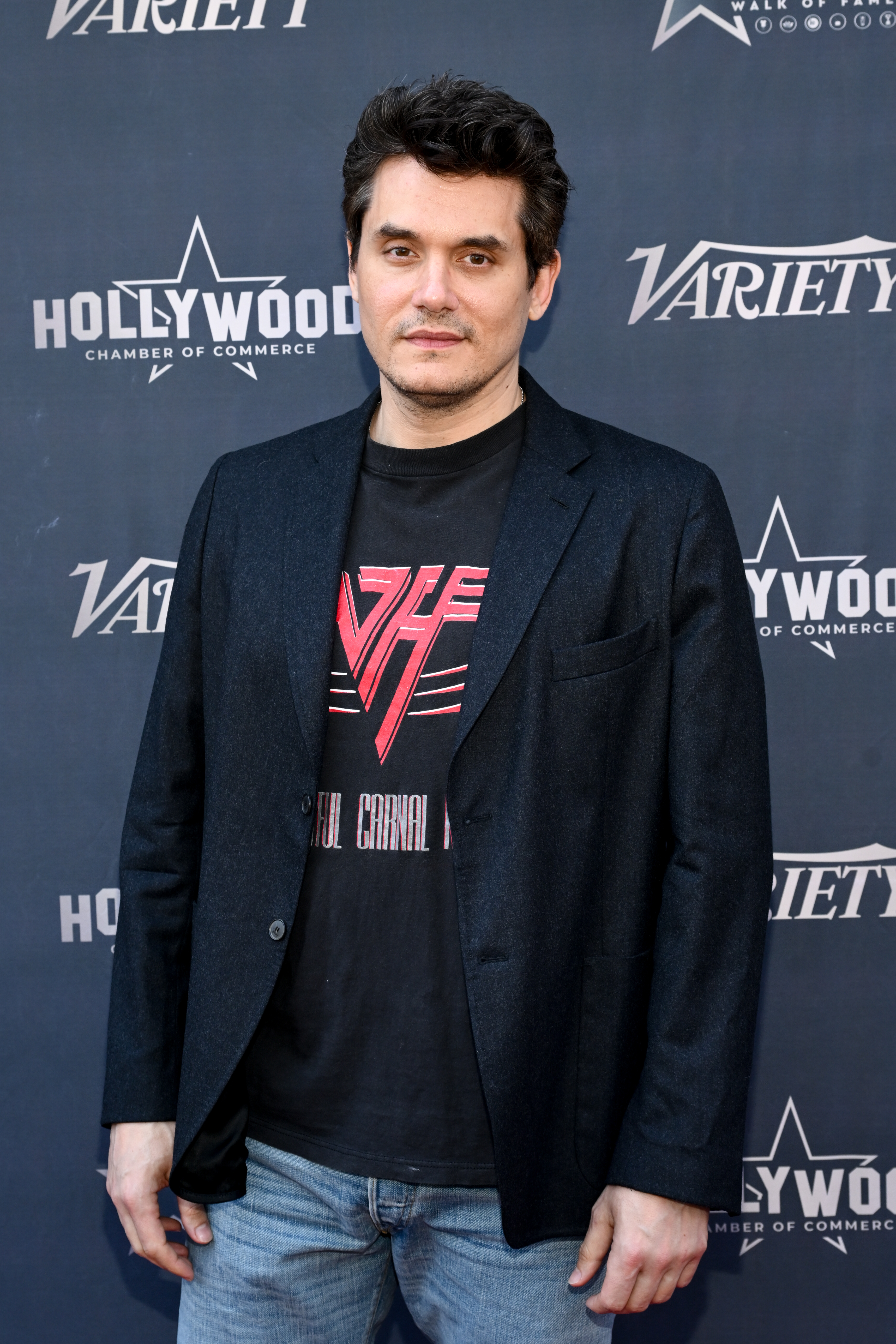 John Mayer in casual attire, wearing a blazer over a graphic T-shirt and jeans, at a Hollywood Chamber of Commerce event partnered with Variety