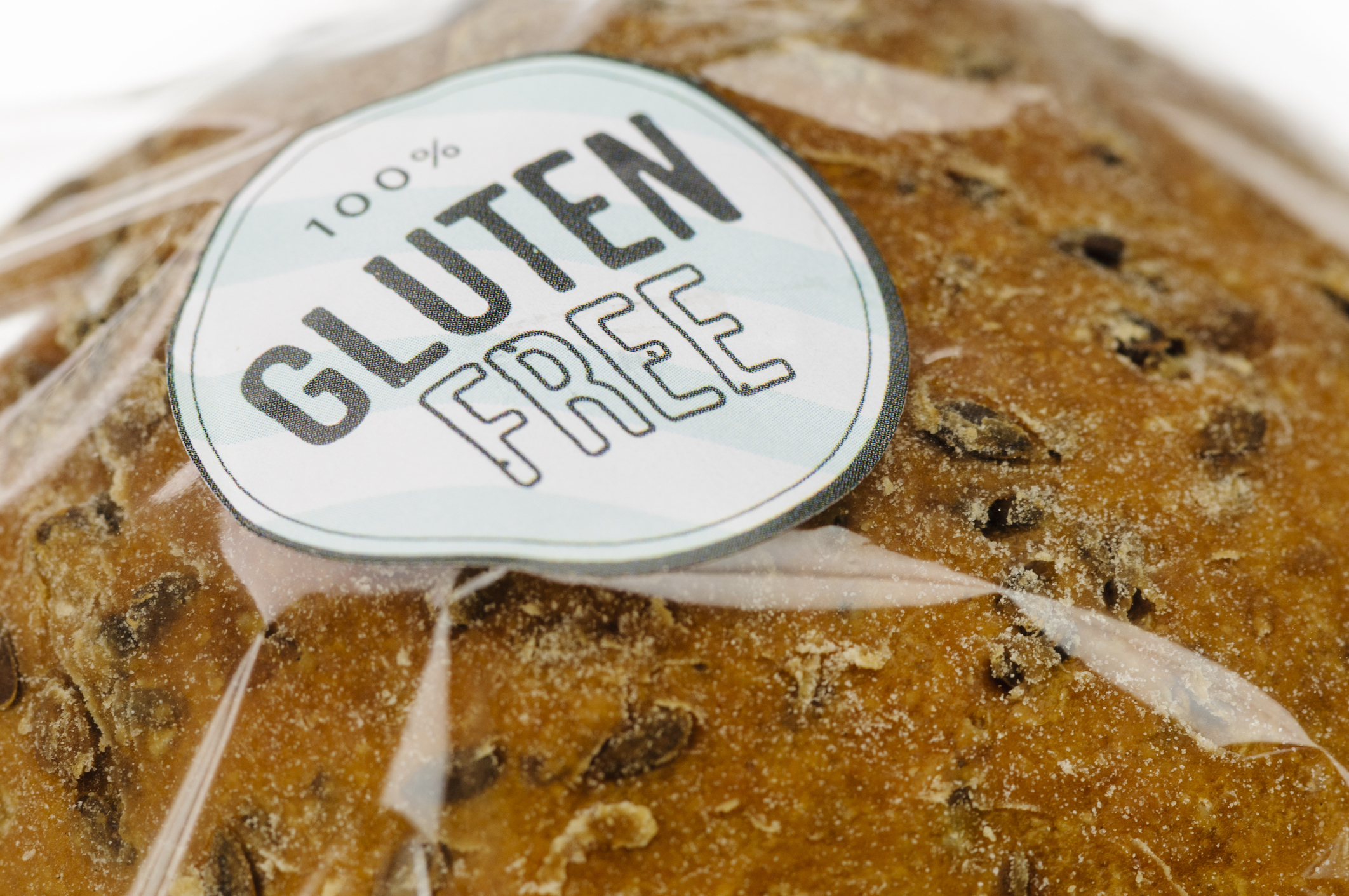 Bread loaf with a label that reads "100% Gluten Free" in large text. The bread has visible whole grains