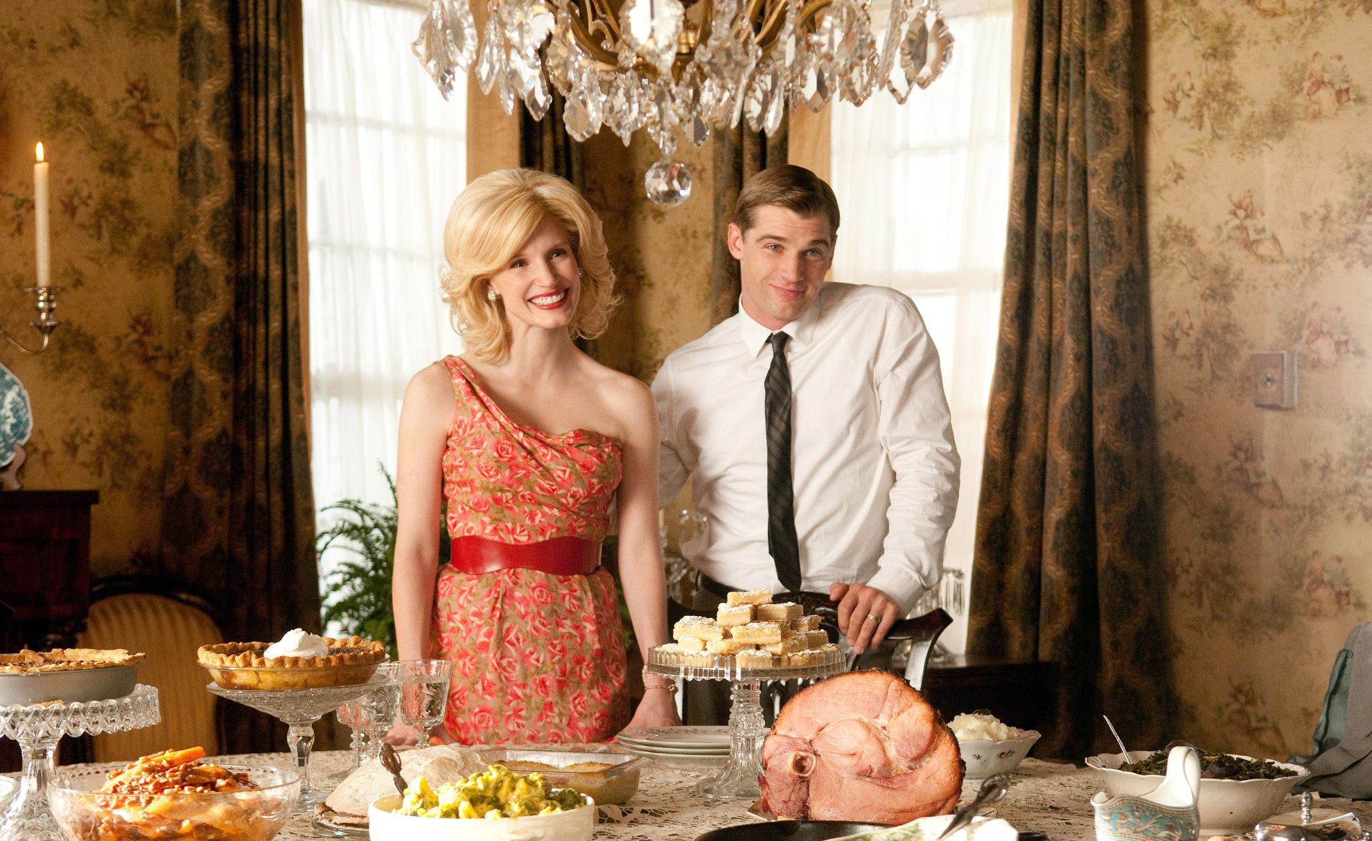 Jessica Chastain and Mike Vogel standing at a table with a large feast in "The Help"
