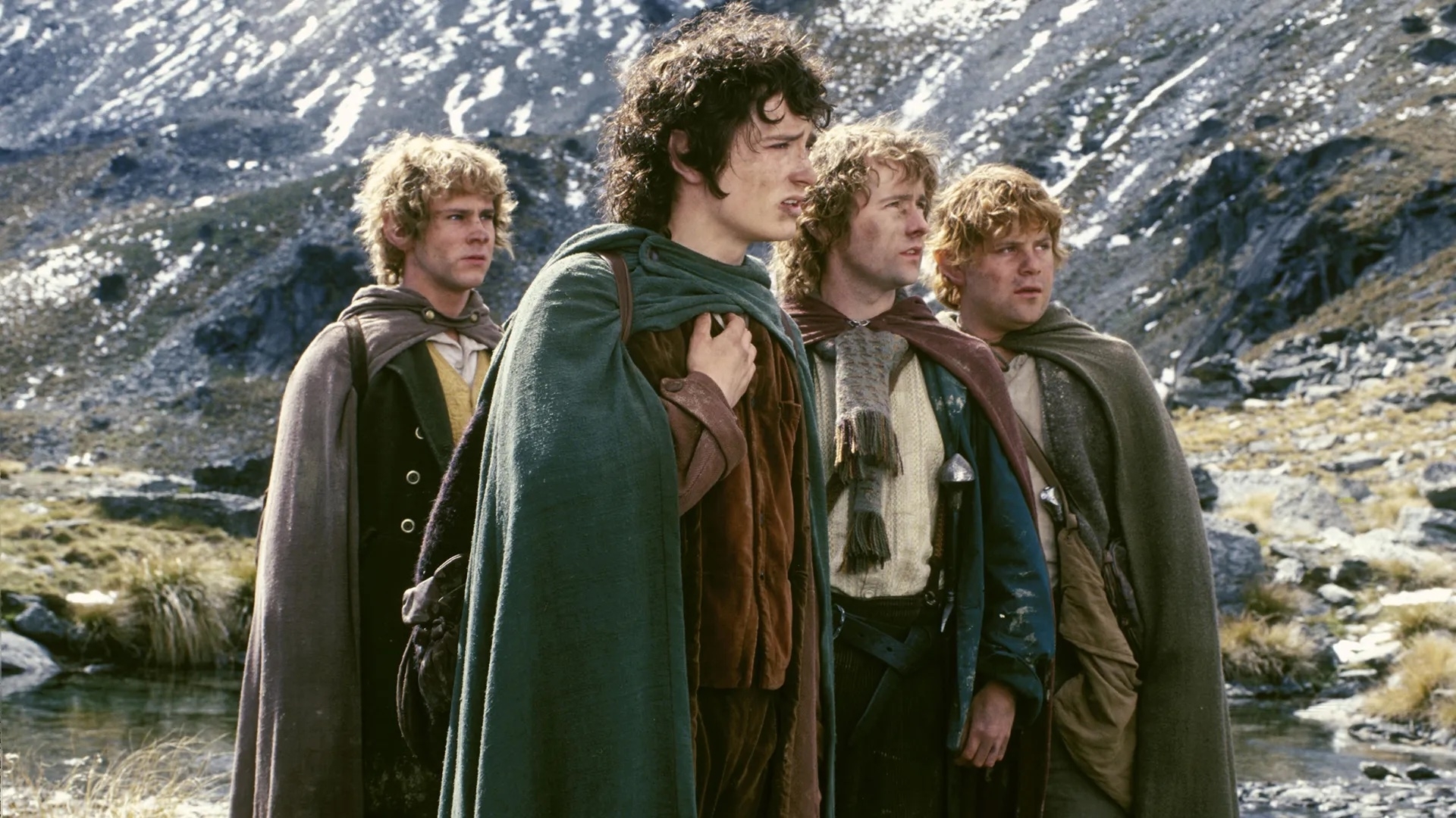 Actors dressed as hobbits in 'The Lord of the Rings': Sam, Frodo, Merry, and Pippin stand together in a mountainous landscape