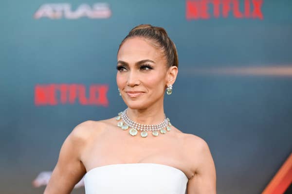 Jennifer Lopez at a Netflix event wearing an elegant strapless dress and a statement necklace