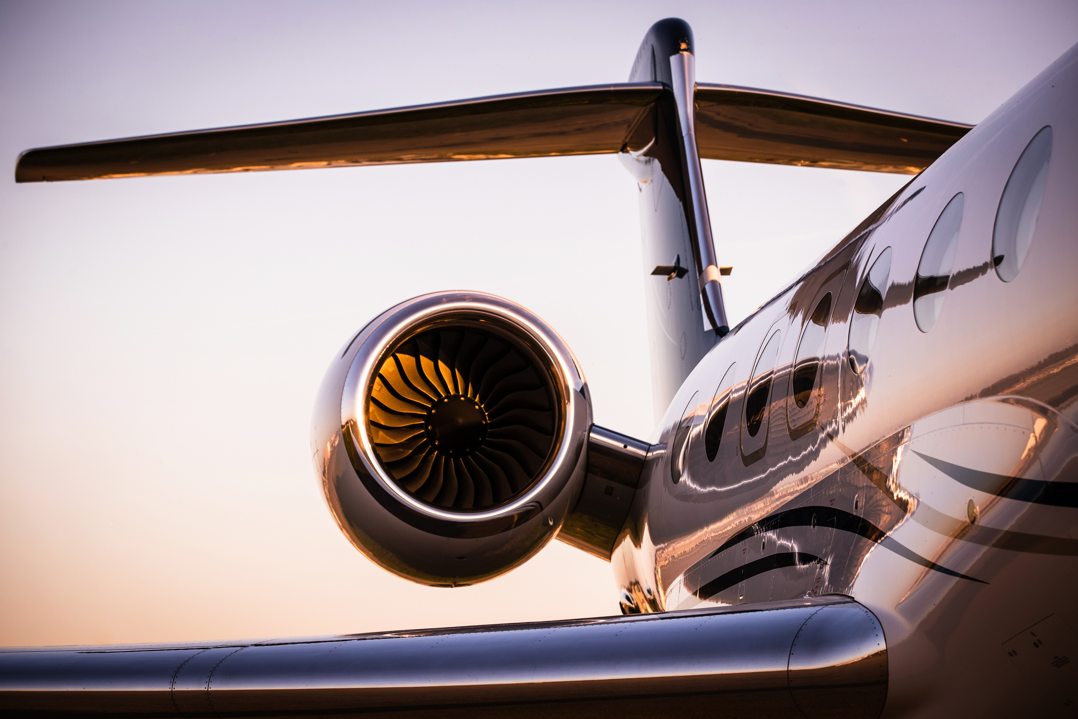Close-up view of a private jet's engine and tail, showcasing luxury air travel. The image adorns an article in the Work &amp;amp; Money category