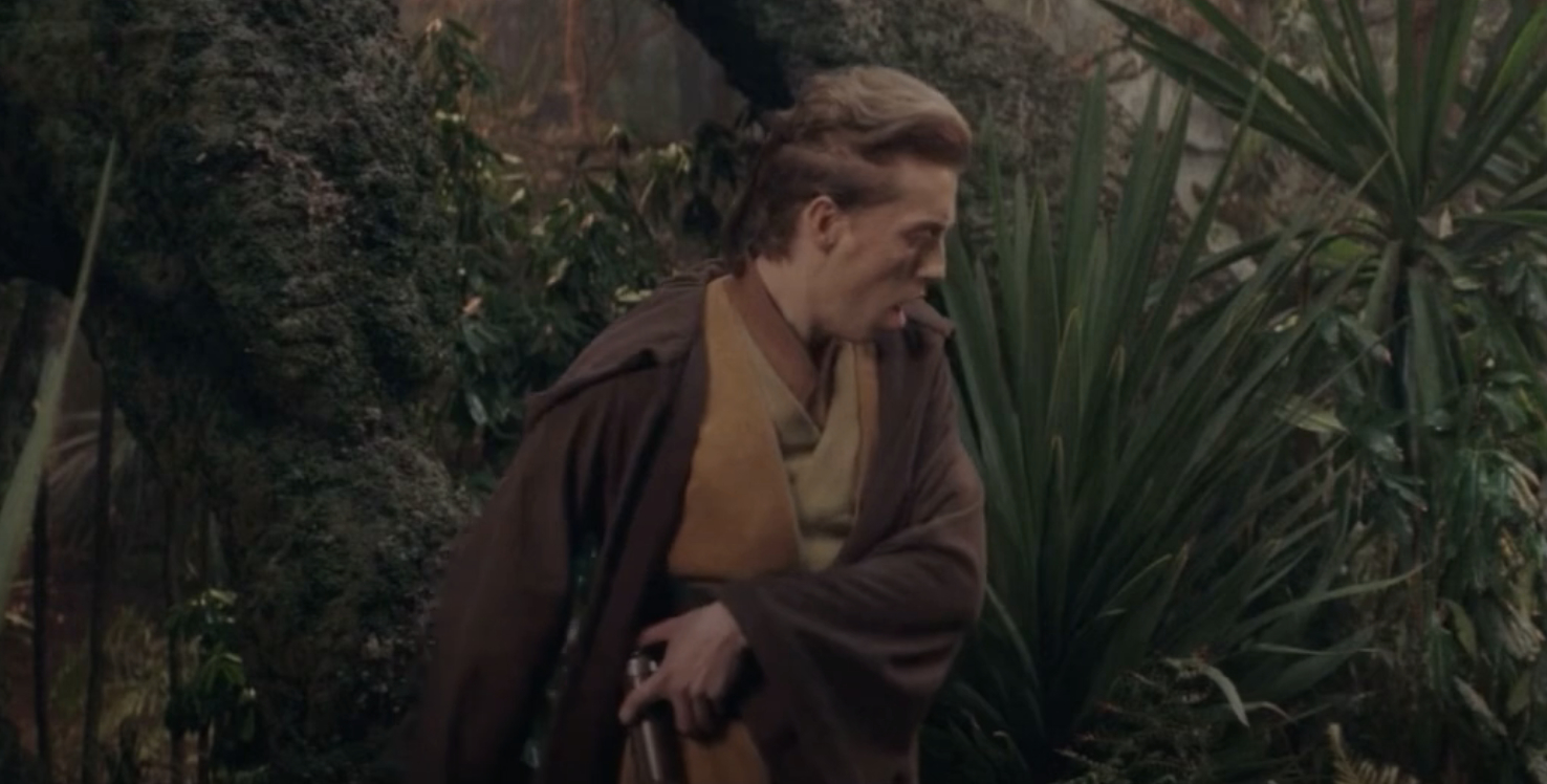 A Jedi in a forest scene, wearing a medieval-style cloak and robe