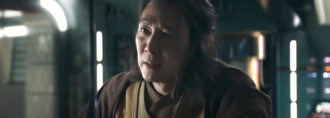 A Jedi in a dimly lit scene, wearing layered robes, portraying a pensive expression