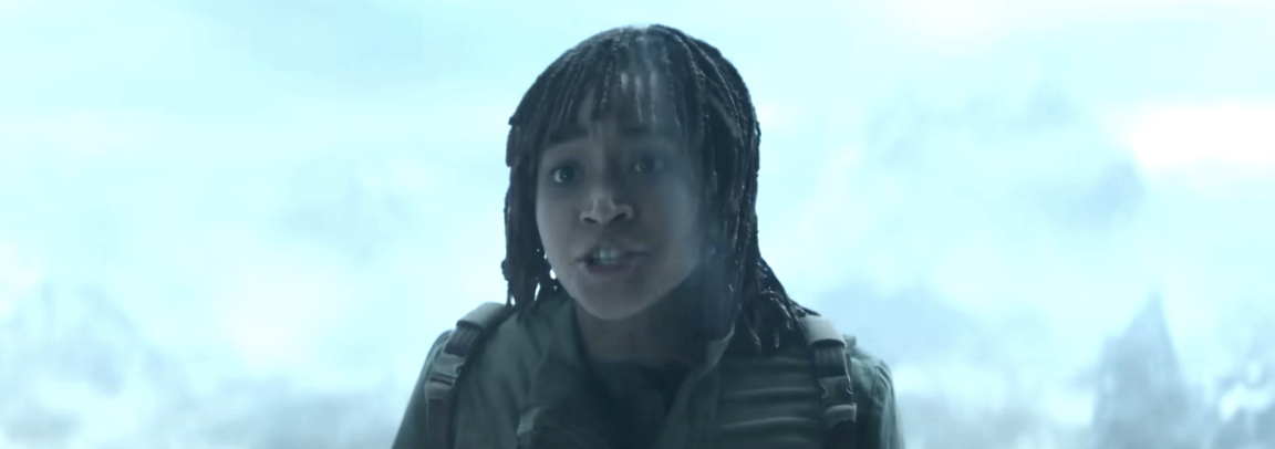 A character wearing outdoor gear speaks in a misty, mountainous environment in a TV show or movie scene