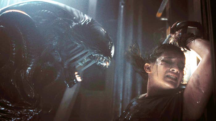 A terrifying Alien creature threatens Ellen Ripley, played by Sigourney Weaver, in a tense scene from the movie. Ripley's expression conveys fear and struggle