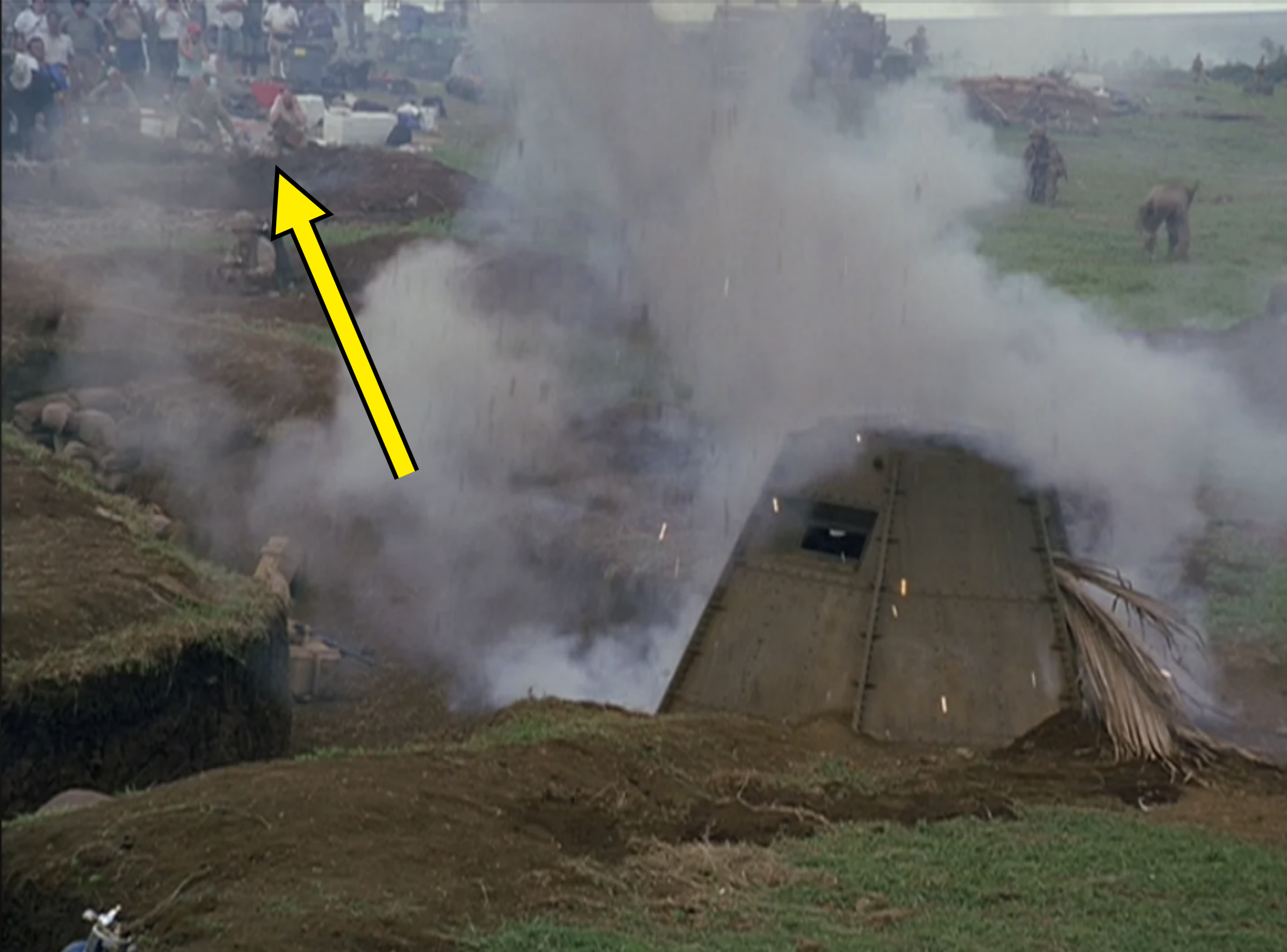 Scene showing a large pit with smoke billowing out, surrounded by people and animals in a rural setting