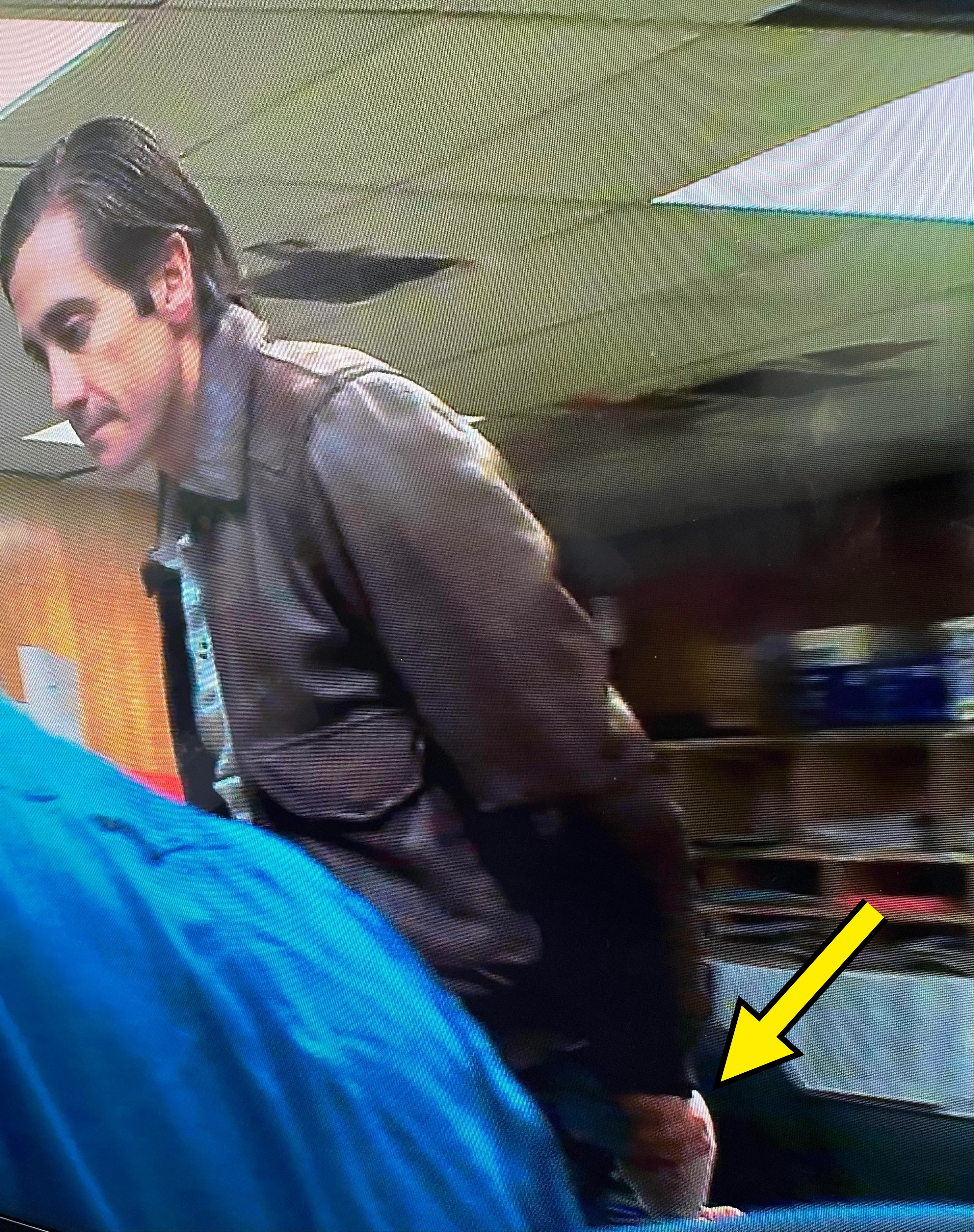 Jake Gyllenhaal wears a leather jacket, leaning over a person in scrubs, in what looks like a room with visible ceiling damage