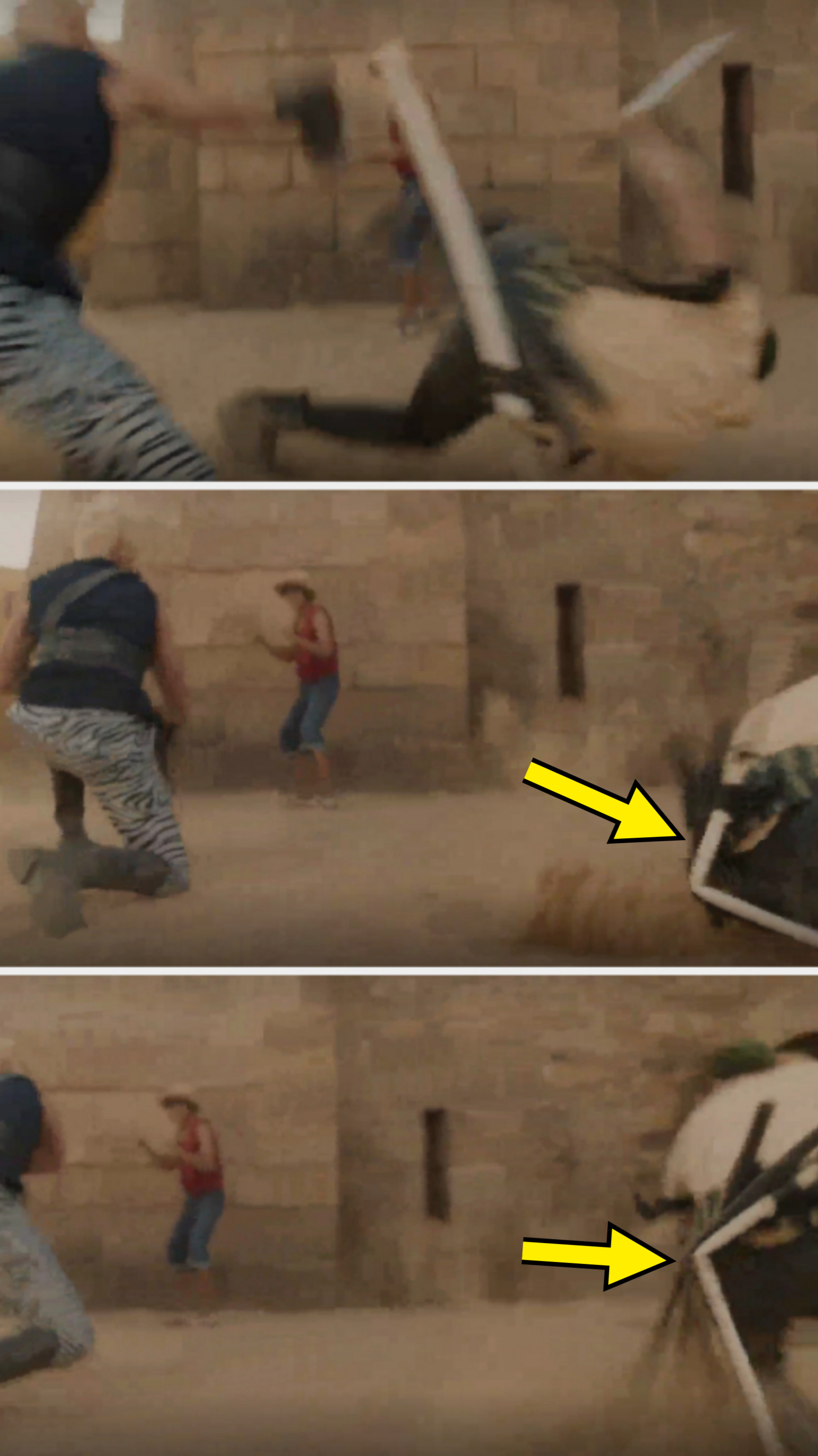 A person is knocked down by a man wielding an object in front of a stone wall. Another person runs toward them in animal print pants and a vest