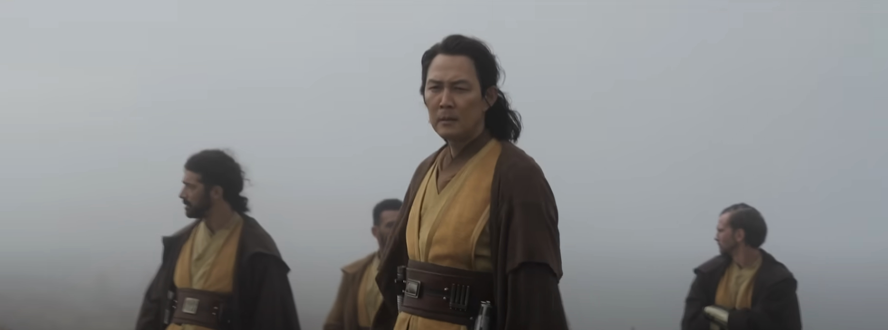 Actors in brown and beige Jedi robes standing in a foggy environment