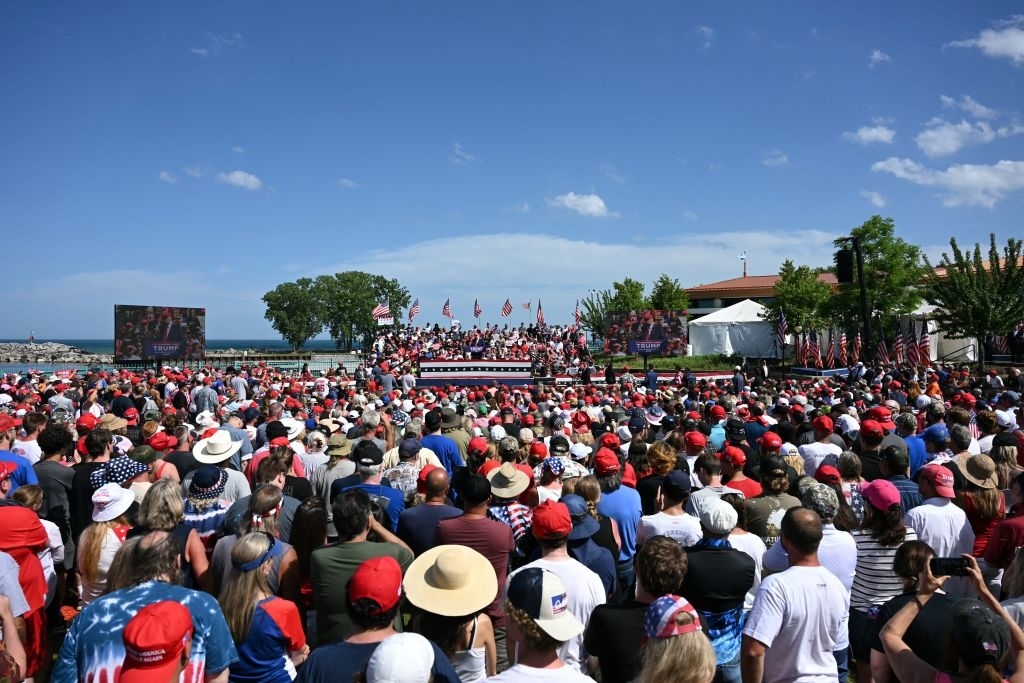 A crowd gathers outdoors for a political rally