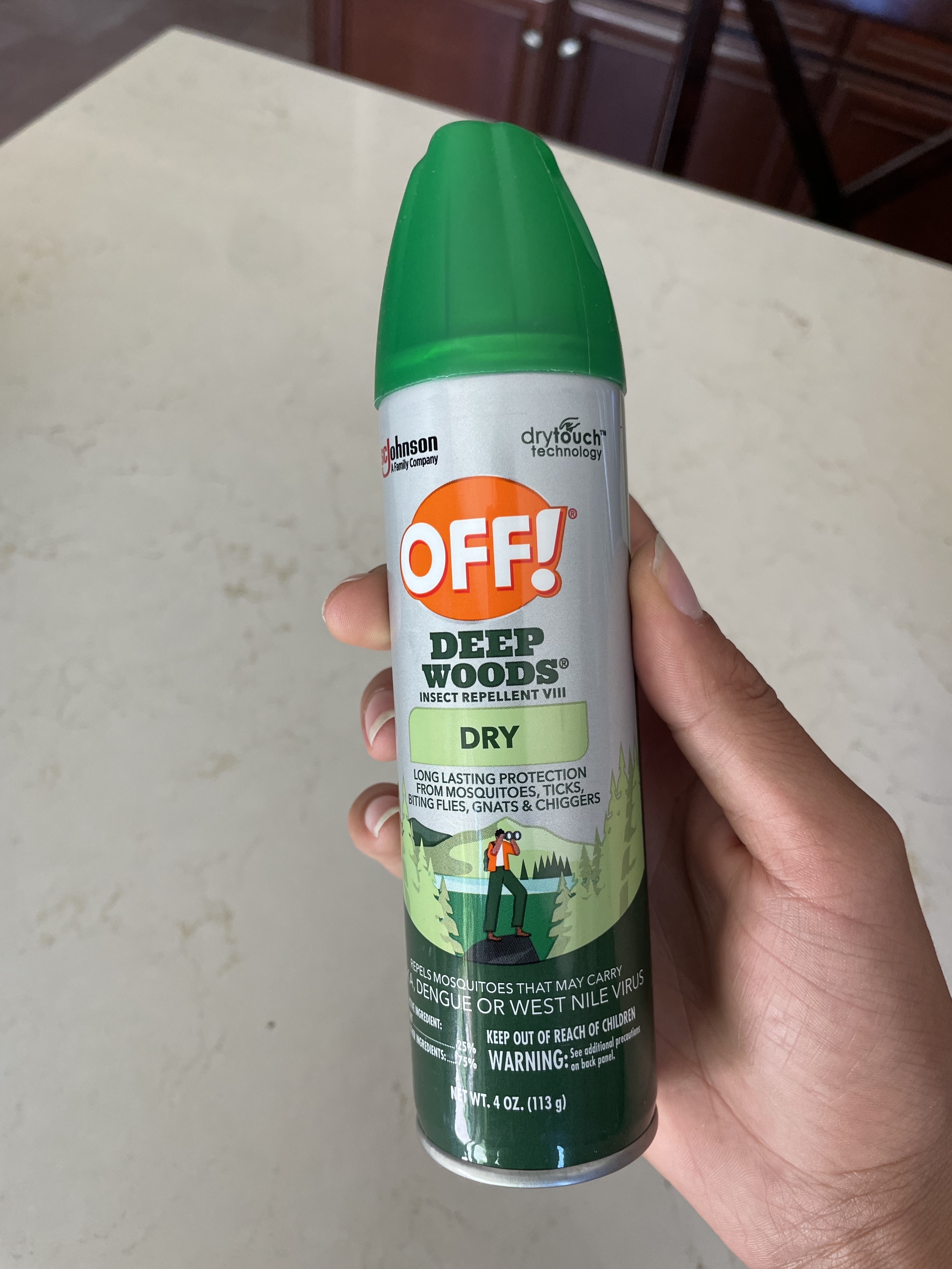 Hand holding a can of OFF! Deep Woods insect repellent