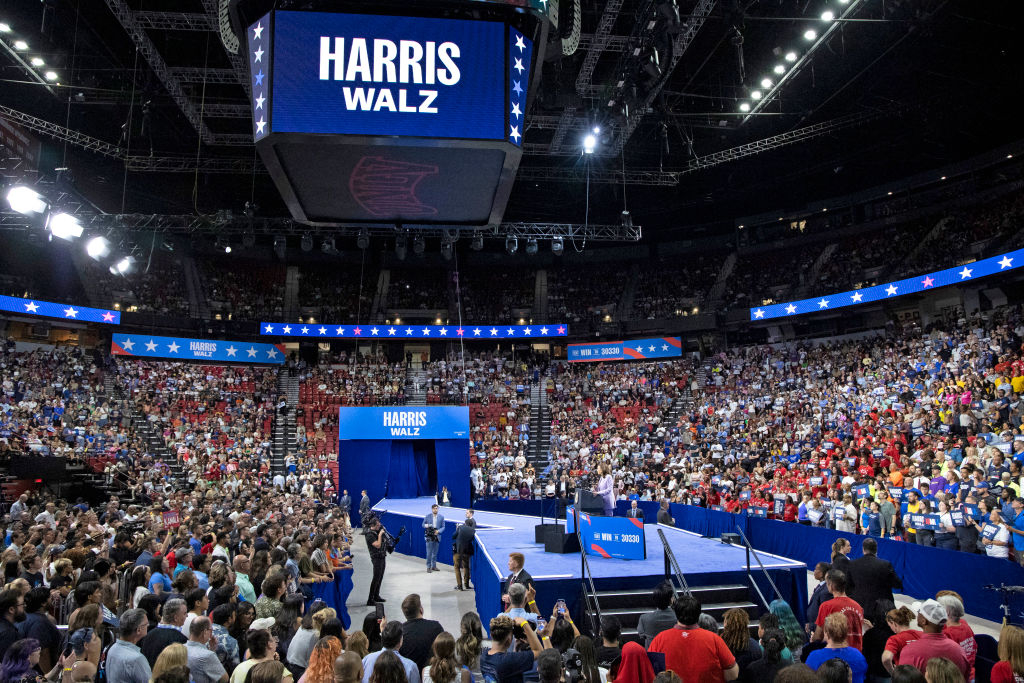 A crowd attends a political rally in an indoor arena