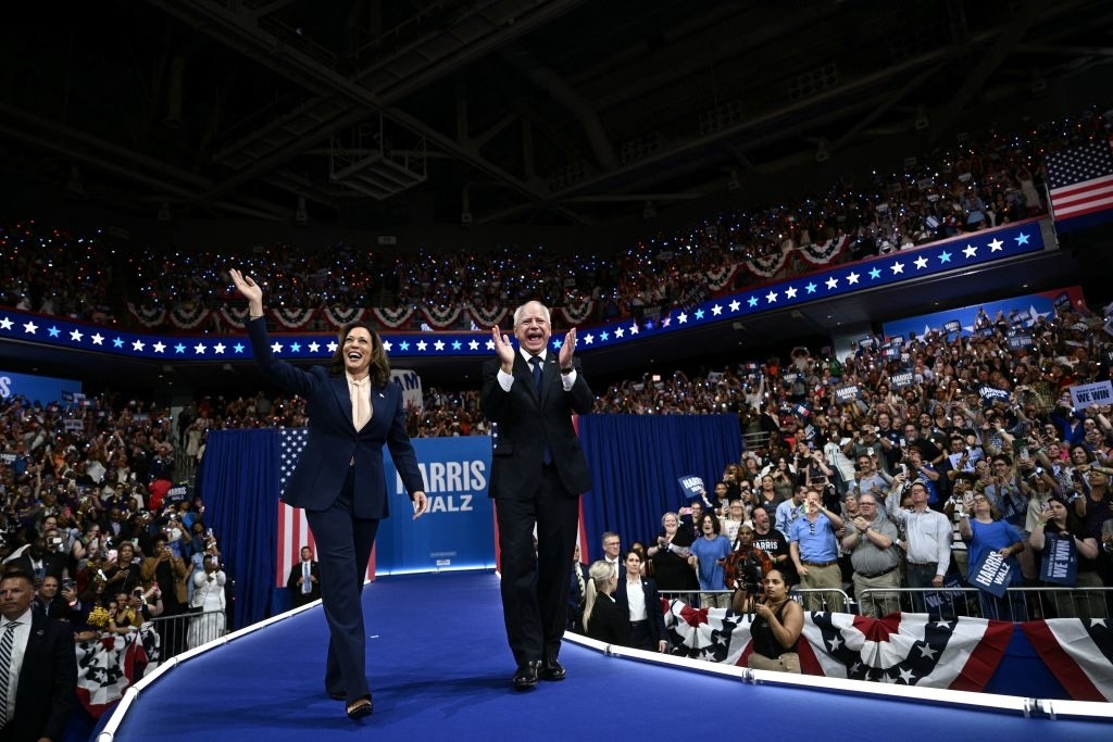 Kamala Harris and Tim Walz wave to a cheering crowd at a rally