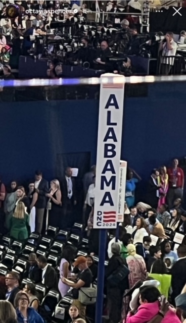 Crowd at a Democratic National Convention, with an "Alabama DNC 2024" sign in the foreground