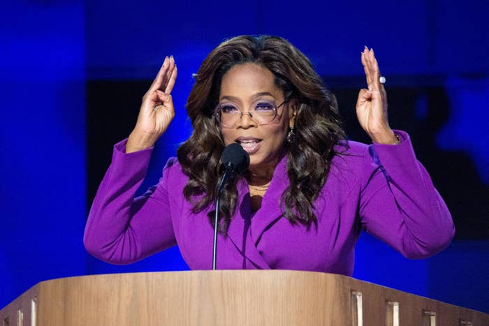 Oprah Winfrey, dressed in a blazer, gestures passionately while speaking at a podium