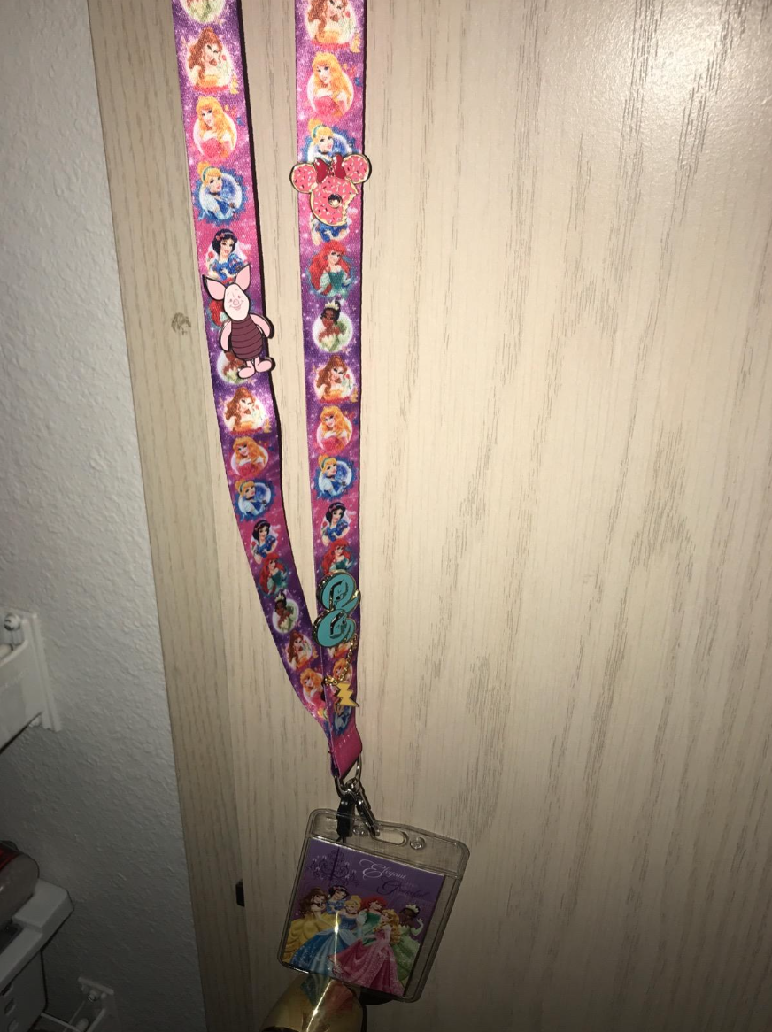 Lanyard with Disney princesses prints, featuring a Minnie Mouse clasp and a clear badge holder with more princess designs