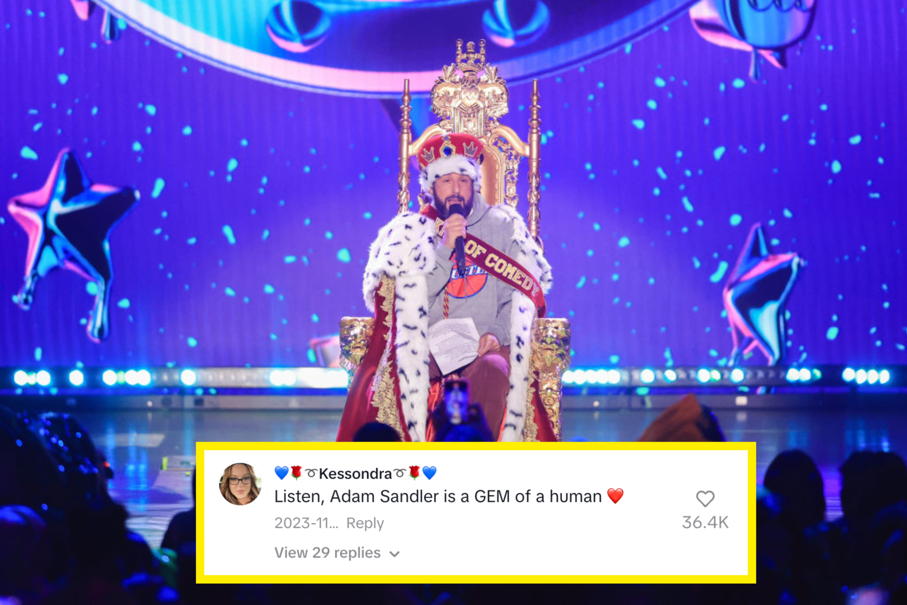 Adam Sandler, sits on a golden throne wearing a crown and fur-trimmed robe on a stage with a backdrop featuring stars