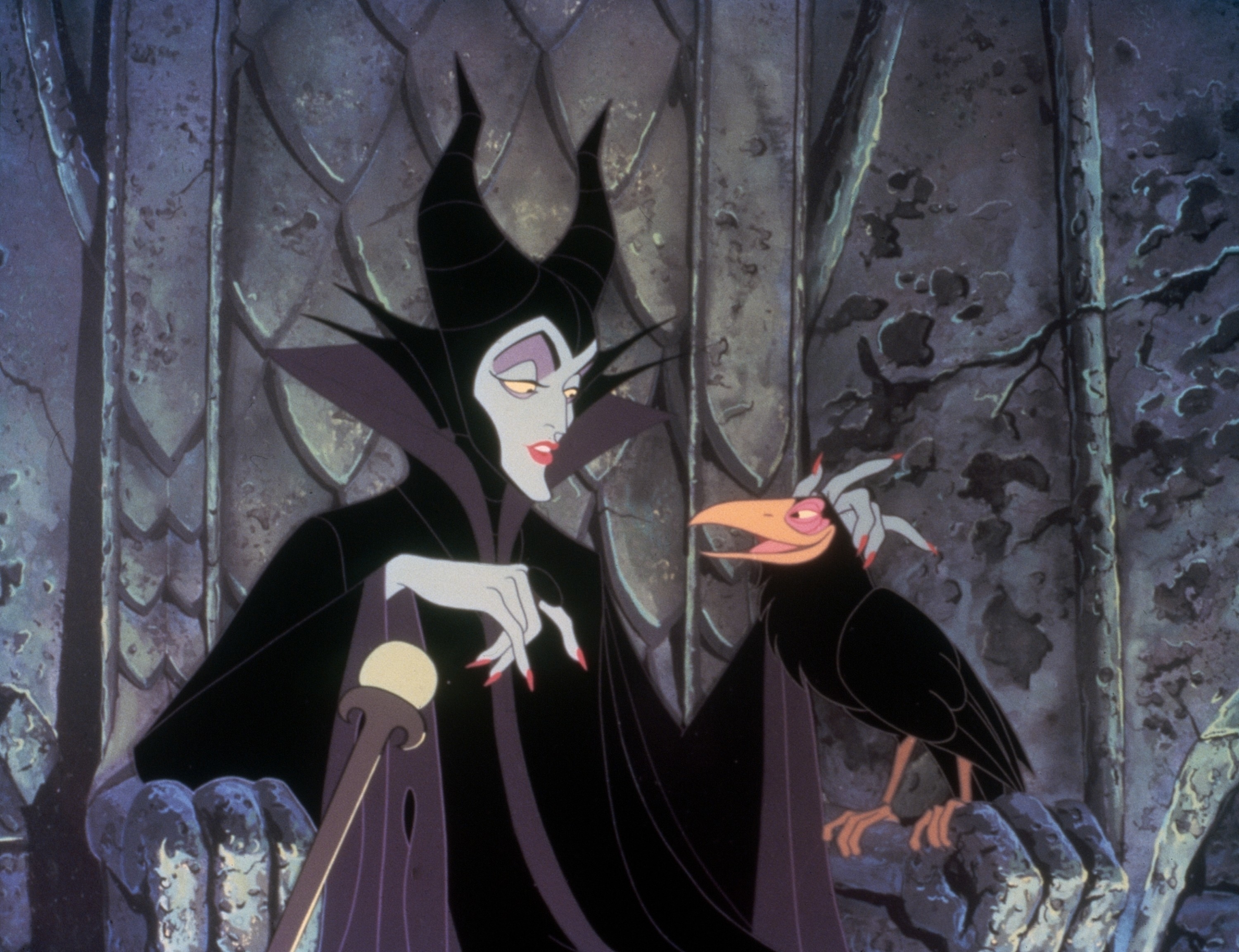 Maleficent, wearing a black horned headdress and robe, sits on a throne with a raven perched on her hand, in a scene from Sleeping Beauty
