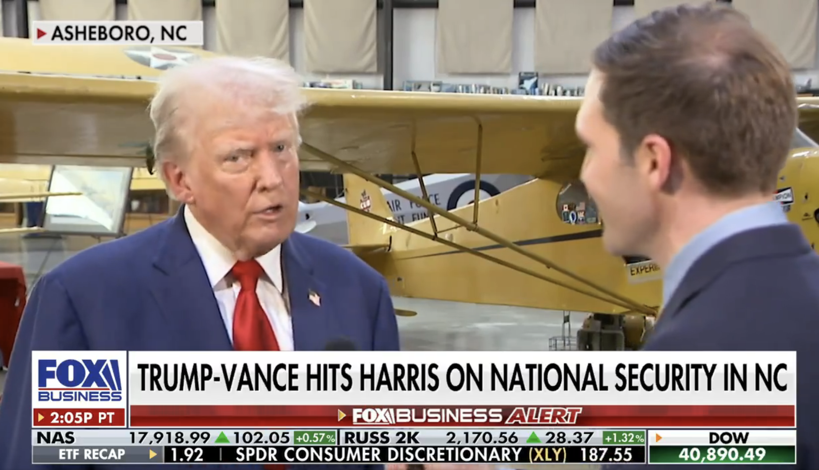 Donald Trump speaking with a reporter in front of an airplane. The caption reads: "Trump-Vance hits Harris on national security in NC"
