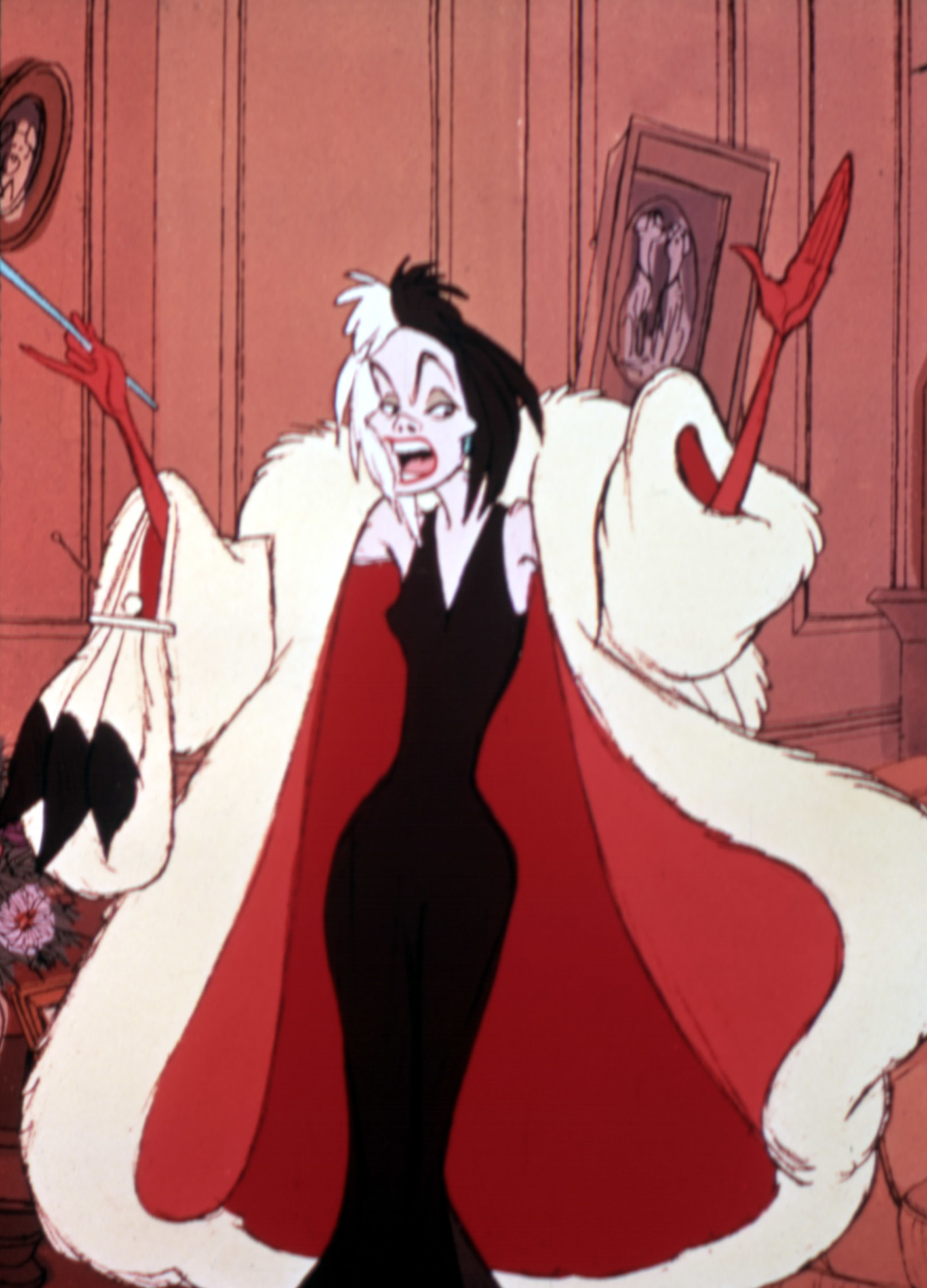 Cruella de Vil from "101 Dalmatians" wears a long black dress and a large white fur coat with red lining, standing with hands raised dramatically