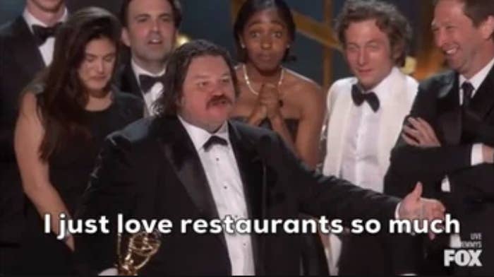 Group of people accepting an award at the Emmys, one man is saying, I just love restaurants so much