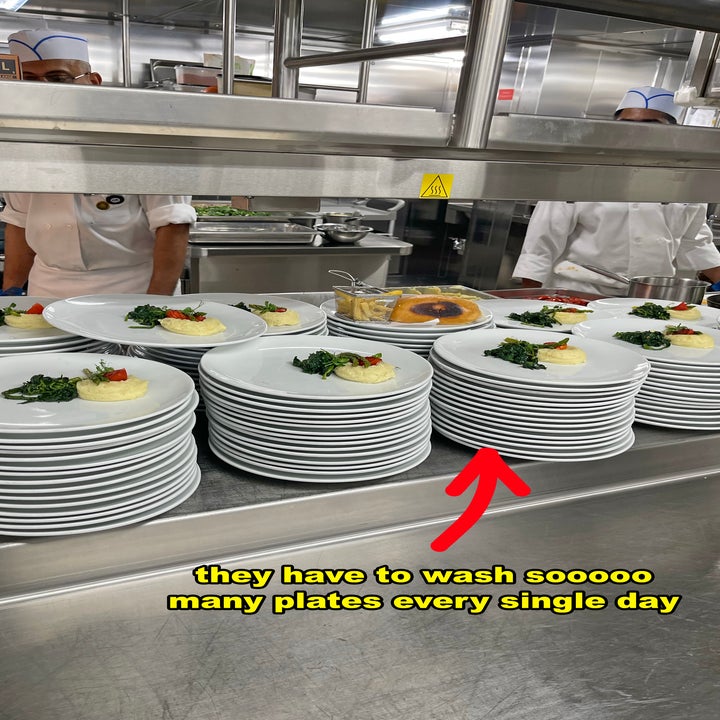 Stacks of clean plates with small portions of food in a commercial kitchen. Text reads, "they have to wash so many plates every single day."