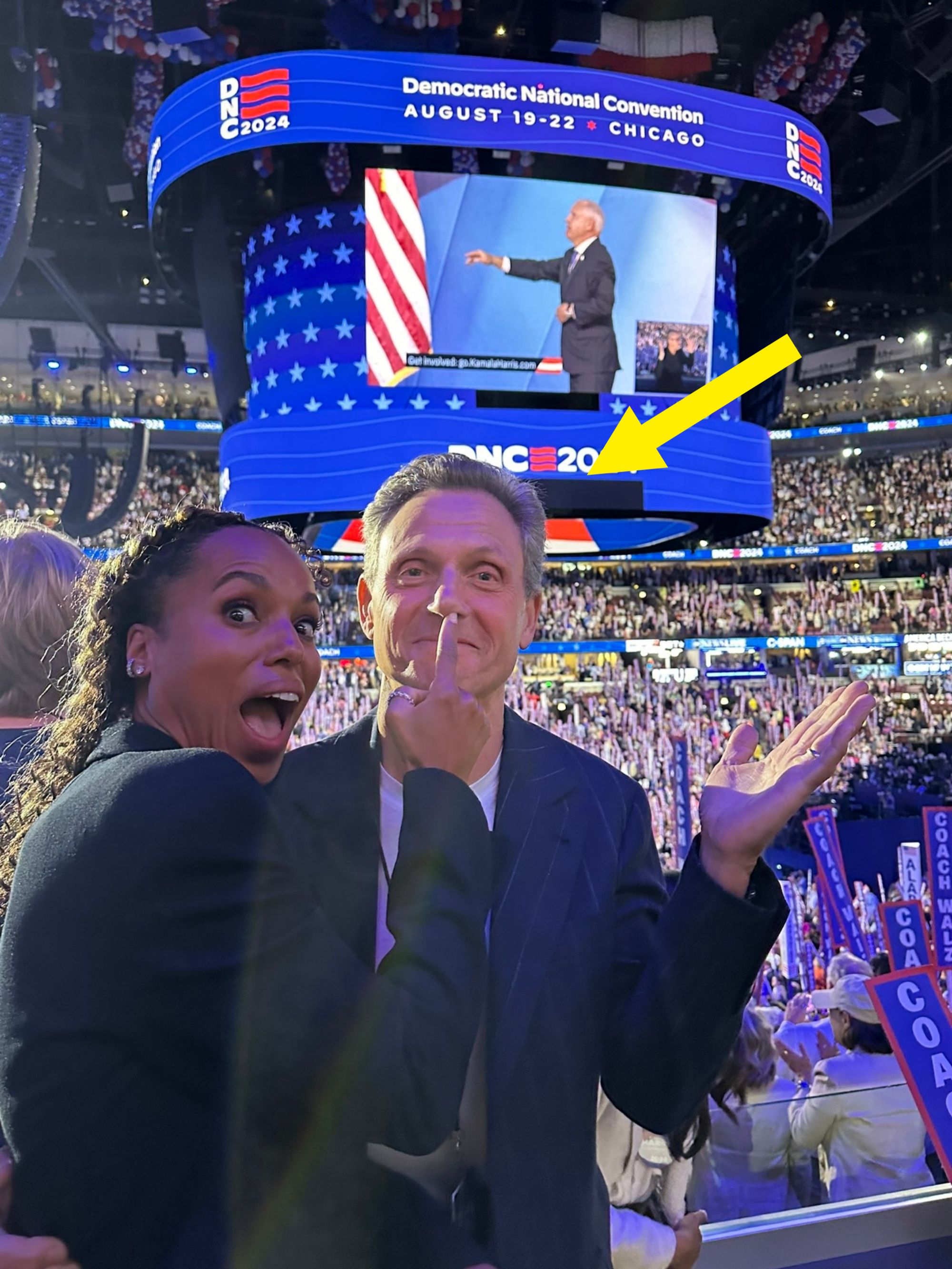 Kerry Washington and Tony Goldwyn at the 2024 Democratic National Convention, excitedly posing with a crowd and large screen in the background