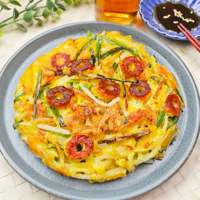 おいしそうな料理が皿に盛られている。近くにはタレが入った皿と箸がある。