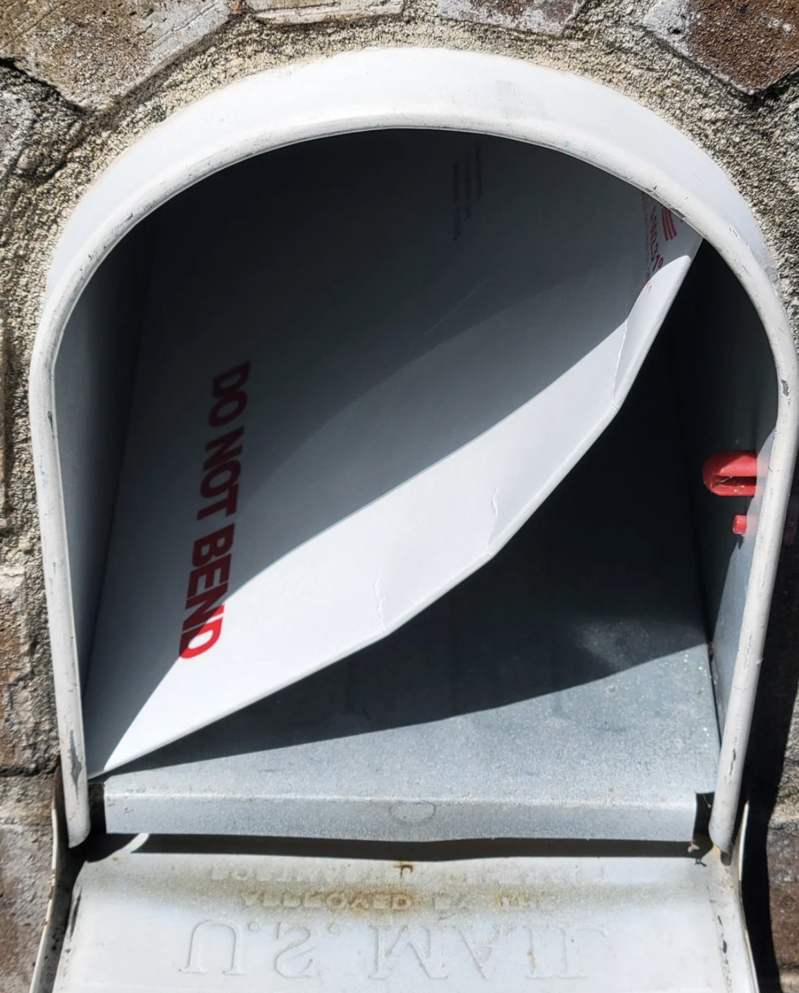 A large envelope labeled "DO NOT BEND" is partially inside a mailbox