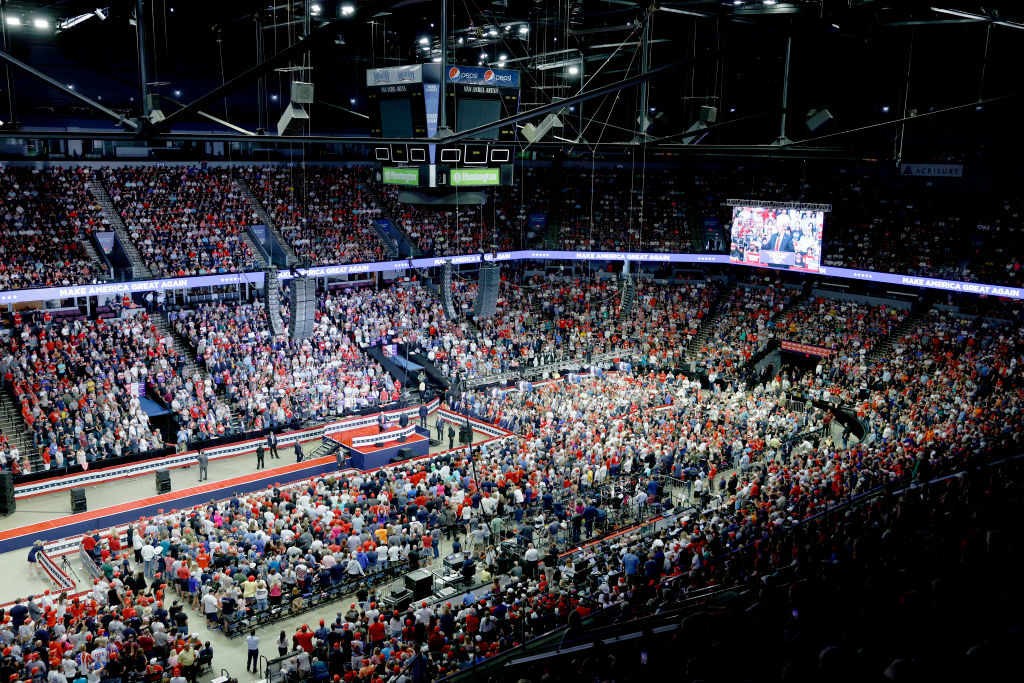 An arena filled with a crowd attending a Trump rally